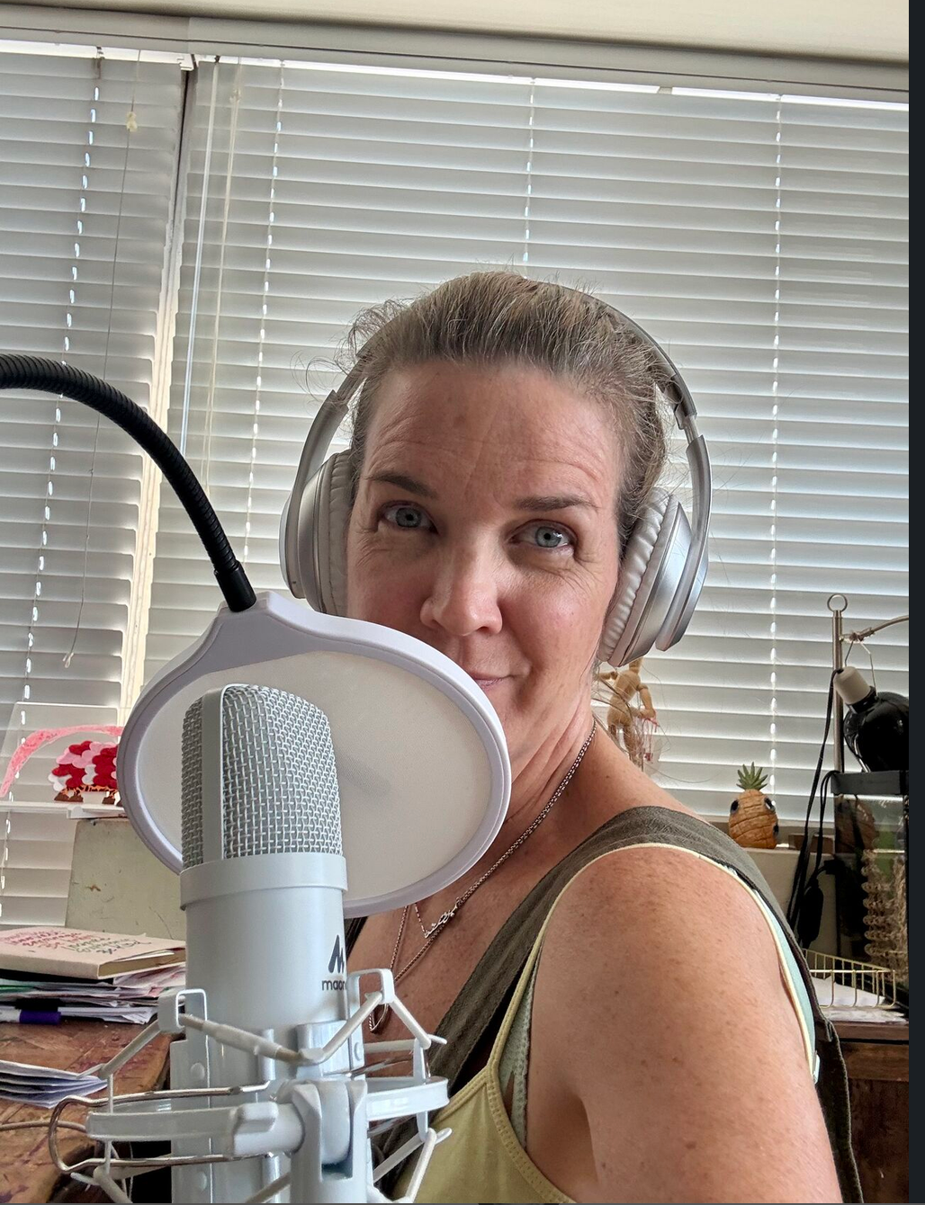 Samantha Hoey Nelson recording the PowerMomma Podcast in headphones at a microphone